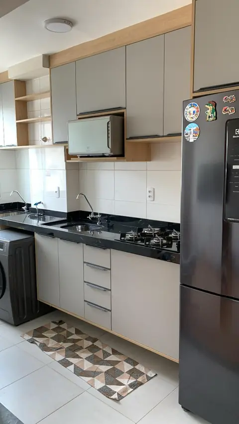 Cozinha planejada com armários cinza e detalhes amadeirados