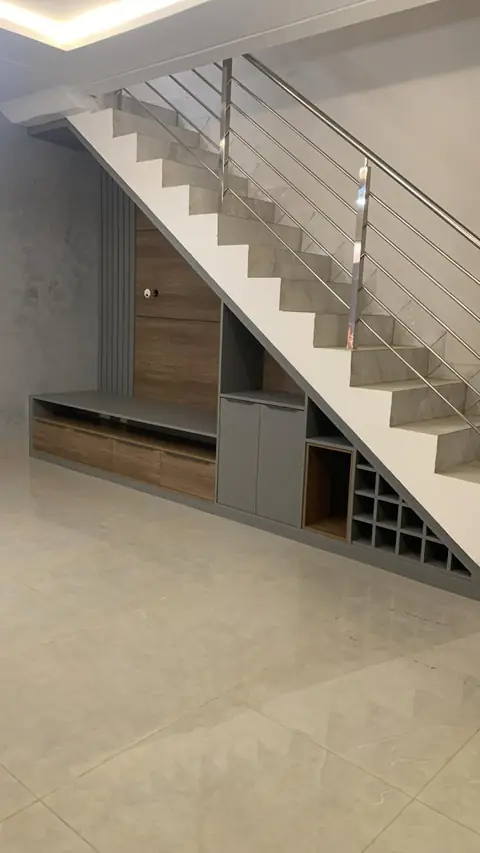 Móvel planejado sob a escada com nichos, portas e adega integrada a um rack